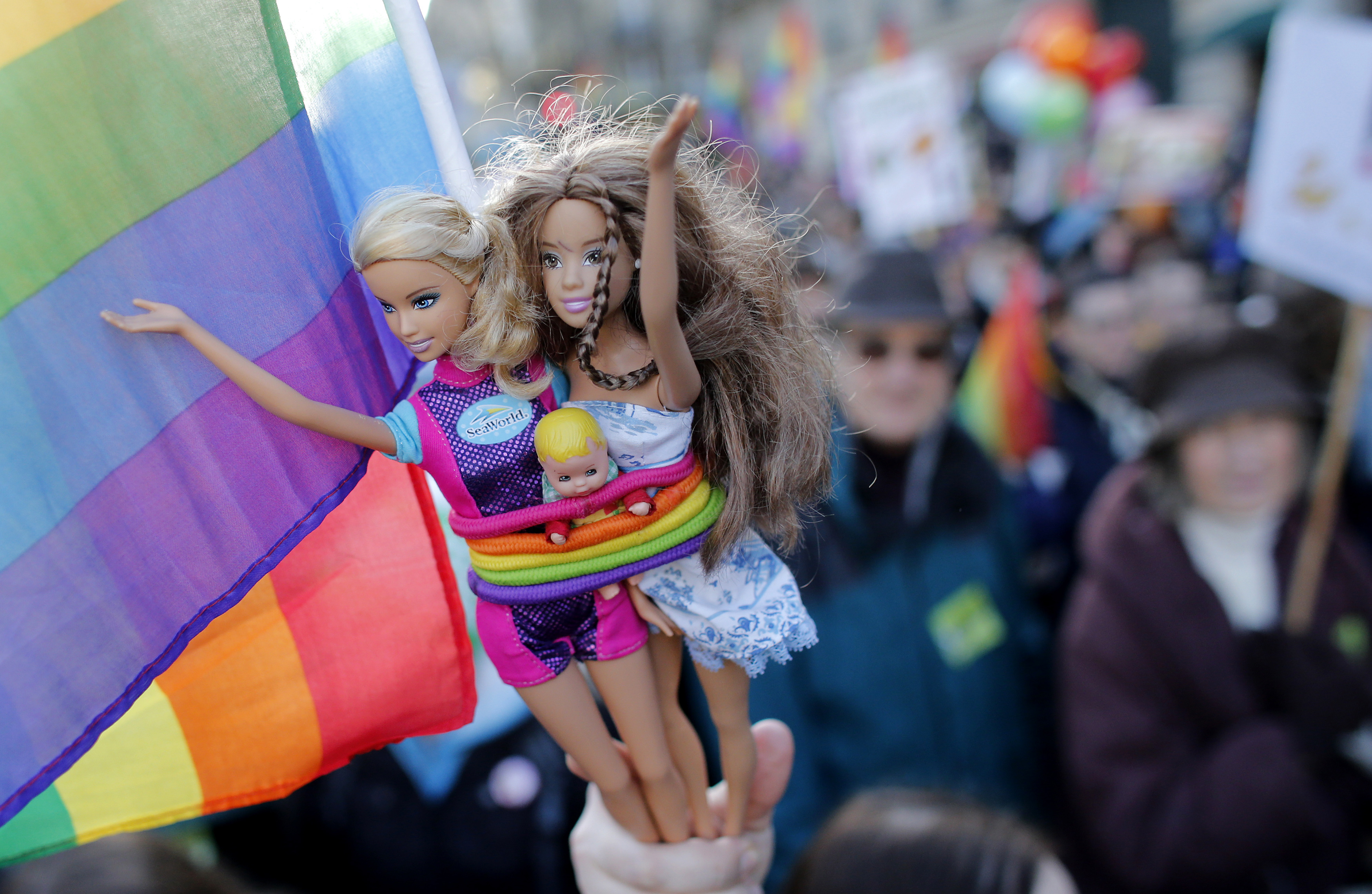 A demonstrator holds Barbie dolls as people march through the streets of Paris in support of the French government's draft law to legalise marriage and adoption for same-sex couples