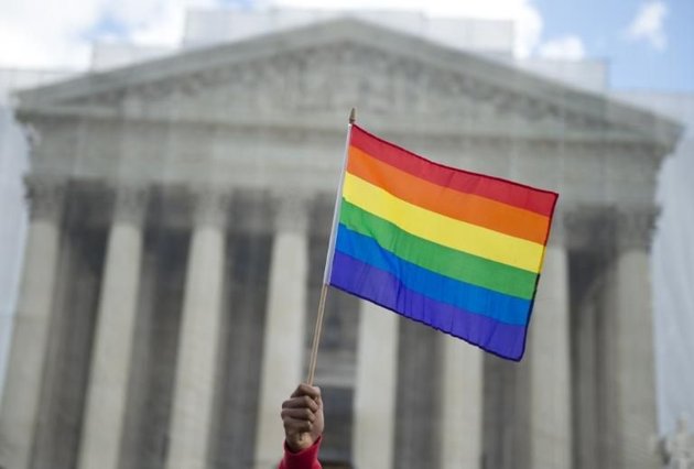 530627-un-partisan-du-mariage-homosexuel-brandit-un-drapeau-arc-en-ciel-le-26-mars-2013-devant-la-cour-supr