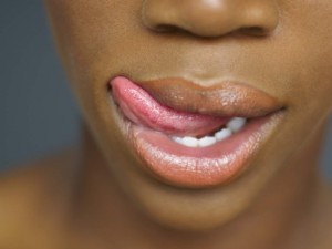 Close up of African woman's mouth with tongue licking lips