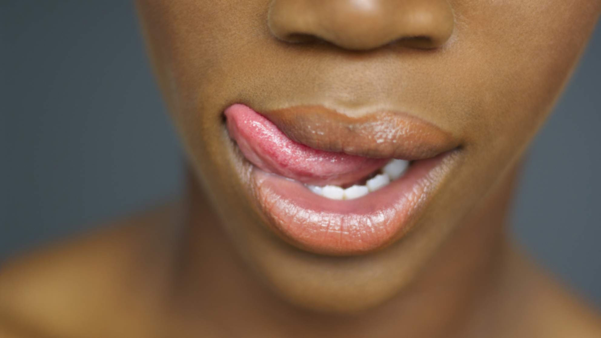Close up of African woman's mouth with tongue licking lips